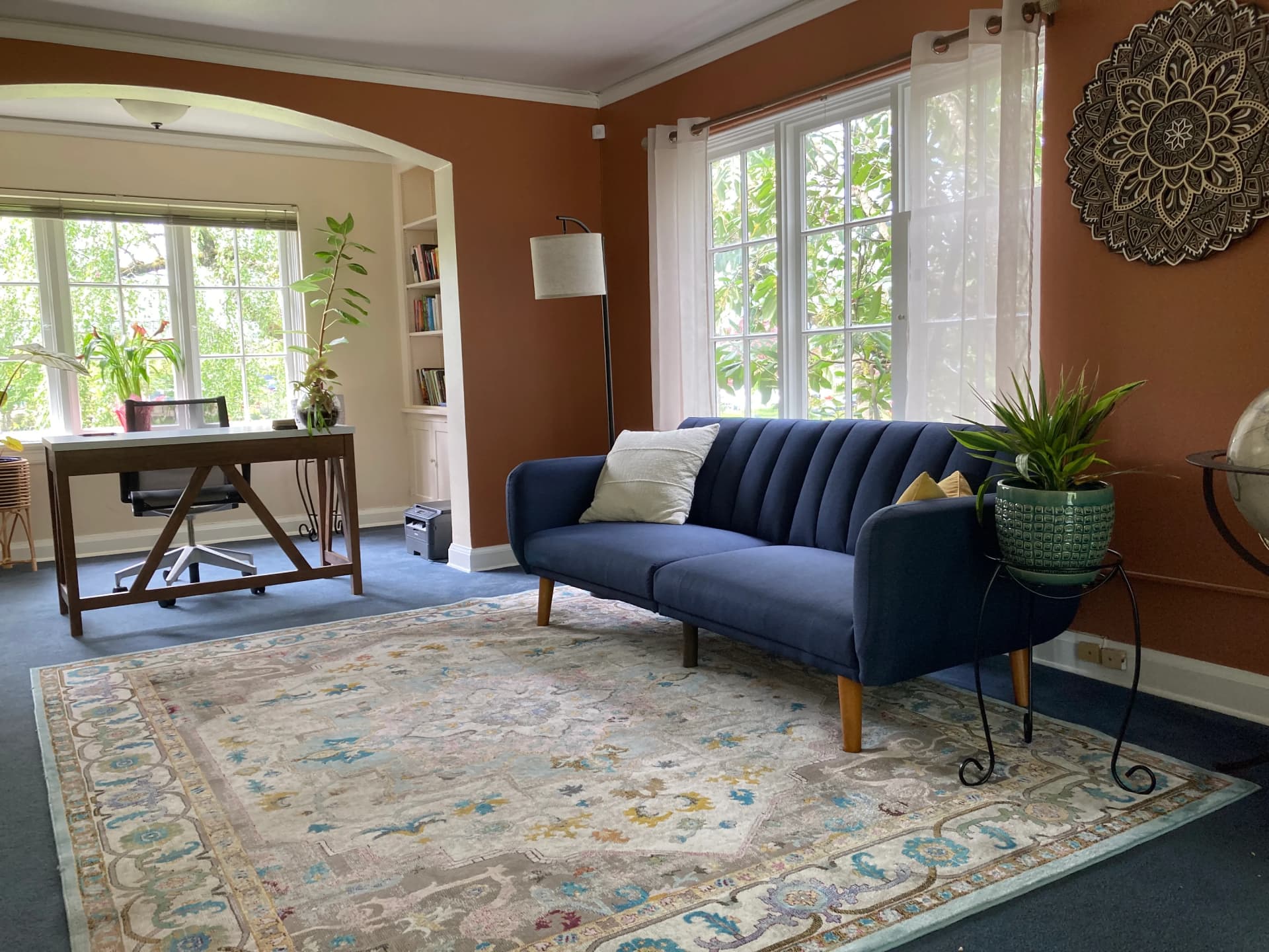 reception area featuring bright windows with a blue couch and several plants